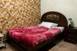 1 dormitorio con 1 cama con cabecero de madera en Hostal Carlos Luis, en Quito
