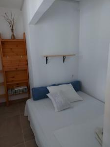 a bedroom with a white bed with a shelf on the wall at Apartmani Kasteljan 7, Stara novalja in Stara Novalja
