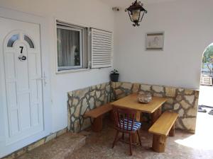 a table and a bench next to a door at Apartmani Kasteljan 7, Stara novalja in Stara Novalja