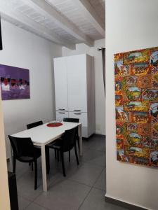 a dining room with a table and chairs and a painting at House il Conte in Palermo