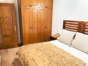 a bedroom with a large bed and a wooden cabinet at Planta baja con jardín en Bor in Bor