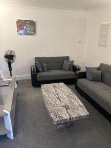 a living room with two couches and a table at Gorgeous 5 bedroom house in Hither Green