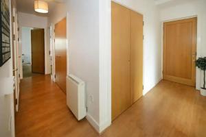 an empty hallway with wooden floors and doors at Bright 2BD Flat with Private Balcony - Dublin in Dublin