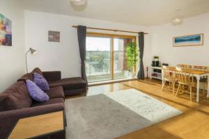 ein Wohnzimmer mit einem Sofa und einem Tisch in der Unterkunft Bright 2BD Flat with Private Balcony - Dublin in Dublin