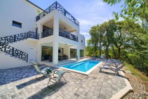an exterior view of a house with a swimming pool at Wellness villa Modruna in Grižane