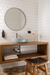 baño con lavabo, espejo y taburete en Hotel Vagabond, en Riccione