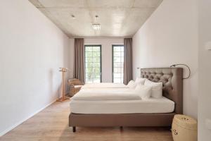 een slaapkamer met 2 bedden en een raam bij havelblau Ferienlofts in Brandenburg an der Havel