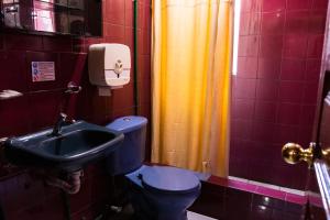 y baño con aseo y lavamanos. en Hostal Carlos Luis, en Quito