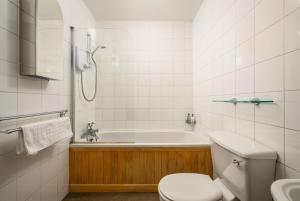 a bathroom with a tub and a toilet and a sink at Retro New Town Garden Flat in Edinburgh