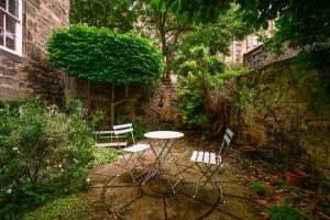 a patio with a table and chairs in a garden at Retro New Town Garden Flat in Edinburgh
