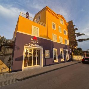 a large yellow building on the side of a street at GRAND - Beachfront Rooms & Apartments in Selce