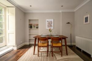 a dining room with a wooden table and chairs at Retro New Town Garden Flat in Edinburgh