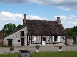 una antigua casa de piedra con techo en Les Hautes Charmante Ferme solognote en Ligny-le-Ribault