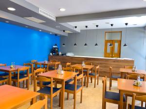 een restaurant met houten tafels en stoelen en een bar bij GRAND - Premium rooms & apartments in Selce