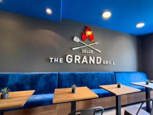 a dining room with a blue couch and tables at GRAND - Beachfront Rooms & Apartments in Selce