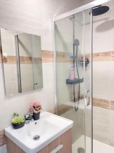 biała łazienka z prysznicem i umywalką w obiekcie Le MonMon des Minimes w La Rochelle