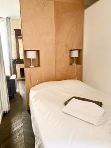 um quarto com uma cama branca com 2 candeeiros em Appartement balcon centre historique em Bordeaux