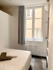 um quarto com uma cama e uma janela em Appartement balcon centre historique em Bordeaux