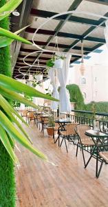 a patio with tables and chairs and plants at رمال الجزيره in Al Ḩawīyah