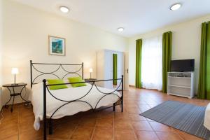 a bedroom with a bed with green pillows on it at Apartments Garden in Motovun