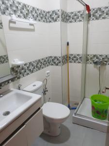 a bathroom with a toilet and a sink and a shower at Appartement standing in Martil