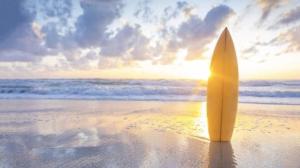 a surfboard sticking out of the sand on a beach at Luna Taghazout - Duplex Luxe - 4 Px in Taghazout