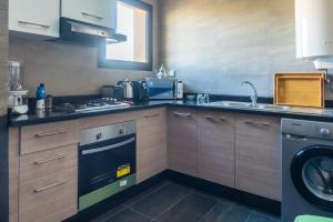 a kitchen with a stove and a dishwasher at Luna Taghazout - Duplex Luxe - 4 Px in Taghazout