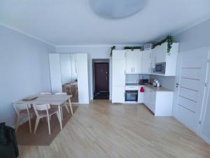 a kitchen with white cabinets and a table and chairs at Great View Studio, self check in, free parking in Klaipėda
