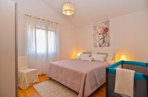 biała sypialnia z łóżkiem i krzesłem w obiekcie House Kacana 2163 w mieście Vodnjan +37 zdjęć