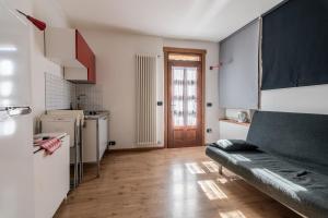 uma cozinha com um sofá no meio de um quarto em Ride Home - Val di Sole em Commezzadura