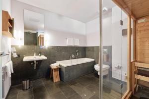 La salle de bains est pourvue d'une baignoire, d'un lavabo et de toilettes. dans l'établissement havelblau Ferienlofts, à Brandebourg-sur-la-Havel