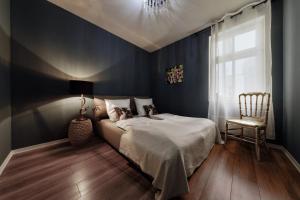 Schlafzimmer mit blauen Wänden, einem Bett und einem Stuhl in der Unterkunft NeuWerk in Erfurt