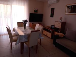a living room with a table and chairs and a television at Apartment Dragica in Ližnjan