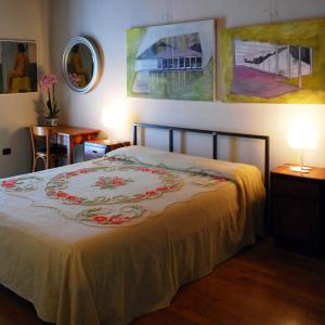 a bedroom with a bed and some paintings on the wall at Camera con vista in Fossombrone