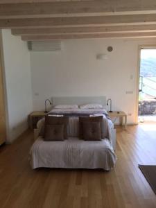 ein Schlafzimmer mit einem Bett in einem weißen Zimmer in der Unterkunft The House on the lake shore in Dervio