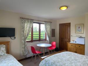 um quarto com uma cama, uma mesa e cadeiras em Sunset House B&B em Penrith