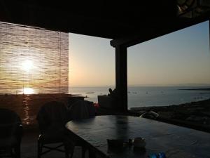 comedor con mesa y vistas al océano en Panoramic villa on top of Capo Falcone en Stintino