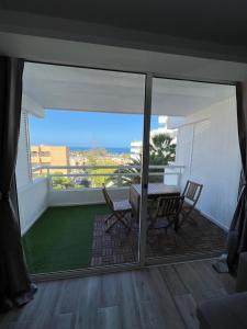 a view of a balcony with a table and chairs at Hideaway Tenerife Holiday Apartment Las Américas in Playa Fañabe