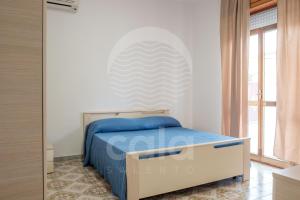 ein Schlafzimmer mit einem Bett und einem großen Fenster in der Unterkunft Villa Odysea - spiaggia a 150m in Torre Lapillo