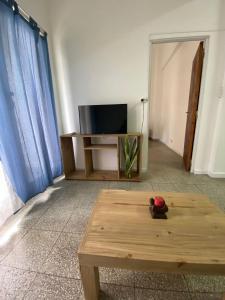 uma sala de estar com uma mesa de café em madeira e uma televisão em Departamento amplio con excelente ubicación em Santa Fé