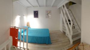 a bedroom with a blue bed and a staircase at Jetez l'ancre dans notre maison de pêcheur ! in Collioure