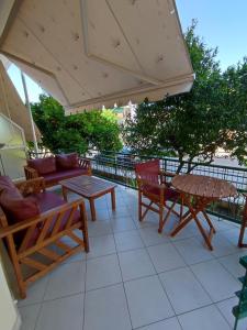 patio ze stołami, krzesłami i parasolem w obiekcie ΠΕΡΣΕΦΟΝΗ w mieście Kamena Wurla