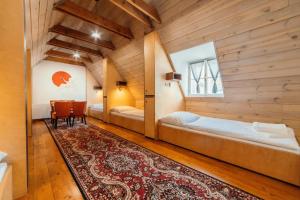 a room with two beds and a table and a rug at HoStel Cosmopolitan* in Banská Štiavnica