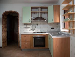 a kitchen with green cabinets and a stove top oven at La casetta sotto ai Crivi in Maratea