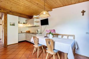 - une cuisine et une salle à manger avec une table et des chaises dans l'établissement Mayrhof Apartment Ahorn, à San Pancrazio