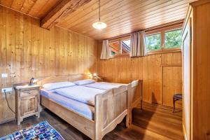 - une chambre avec un lit dans une pièce dotée de murs en bois dans l'établissement Mayrhof Apartment Ahorn, à San Pancrazio