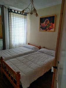 two beds in a bedroom with a window at urb el refugio , brañavieja-alto campoo in Brañavieja