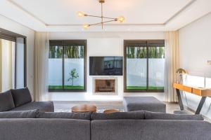 uma sala de estar com um sofá e uma televisão em Houd Taghazout - luxury villa - Pool - 6 or 7 Px em Taghazout