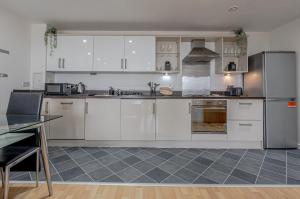 a kitchen with white cabinets and stainless steel appliances at Modern 2BR Apartment City Centre Free Secure Parking Stunning Views in Birmingham