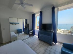a bedroom with a bed and a television and a window at VarazzeSuite Endless Sea in Varazze